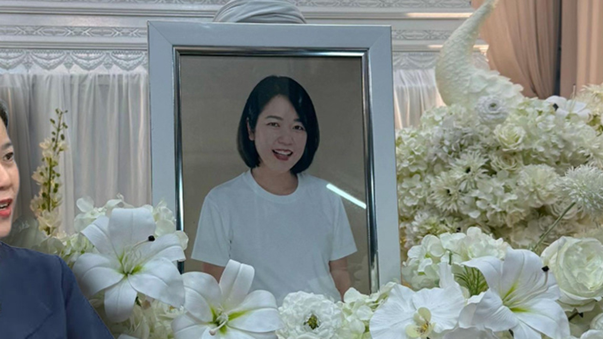 ภาพบุคคลในกรอบท่ามกลางดอกไม้ไว้อาลัย