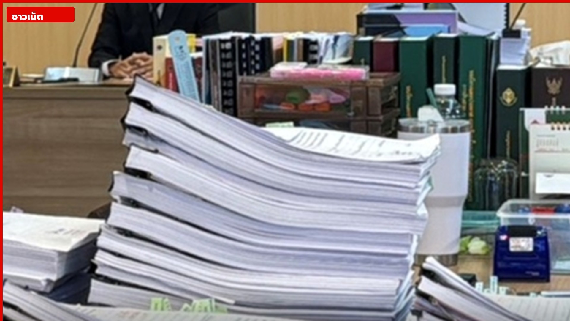 กองเอกสารหนีบคลิปดำกองบนโต๊ะประชุม