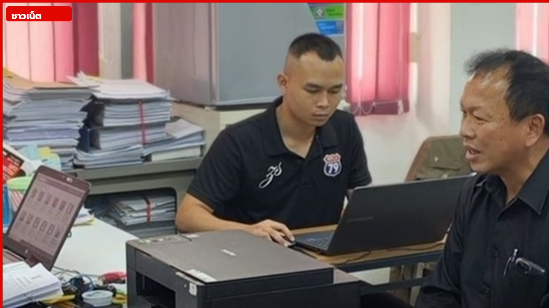 เจ้าหน้าที่นั่งแจ้งความเรื่องโฉนดที่ดินในห้องทำงาน