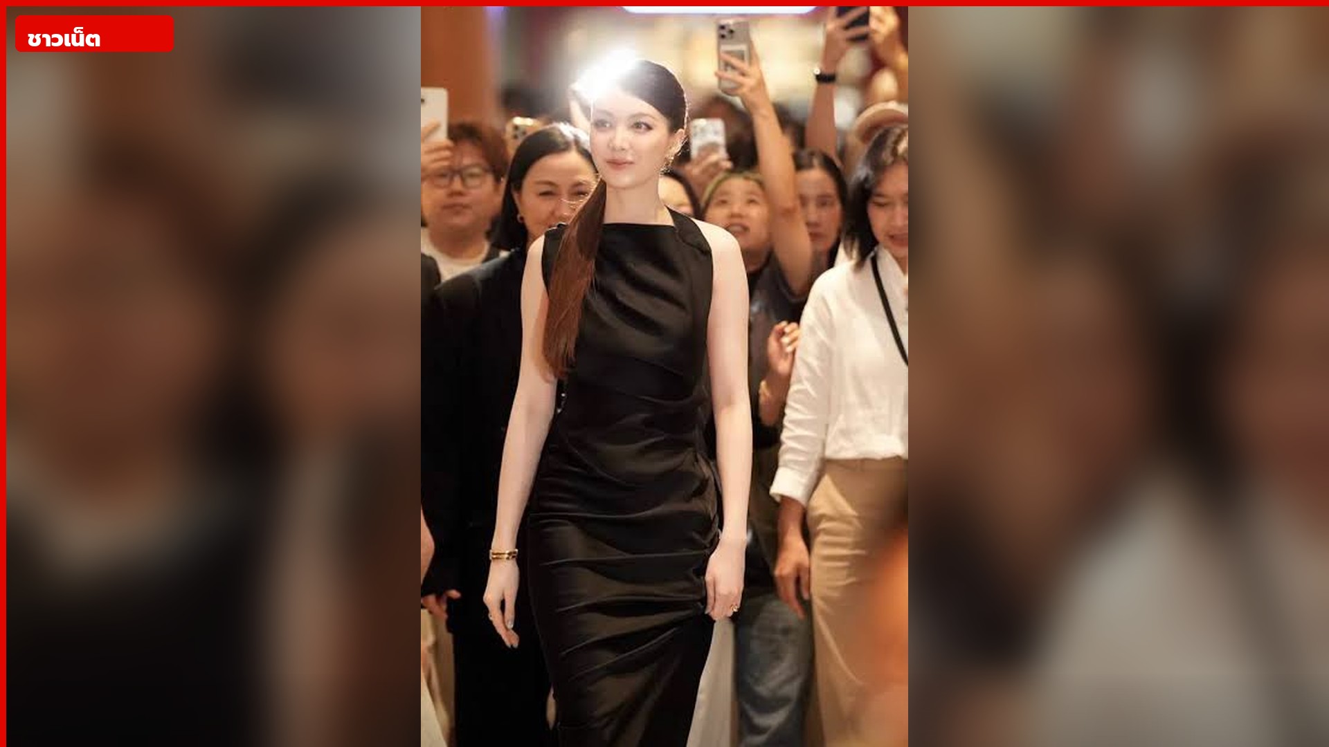 ออม กรณ์นภัสเดินผ่านผู้คนที่ถ่ายรูปในงาน