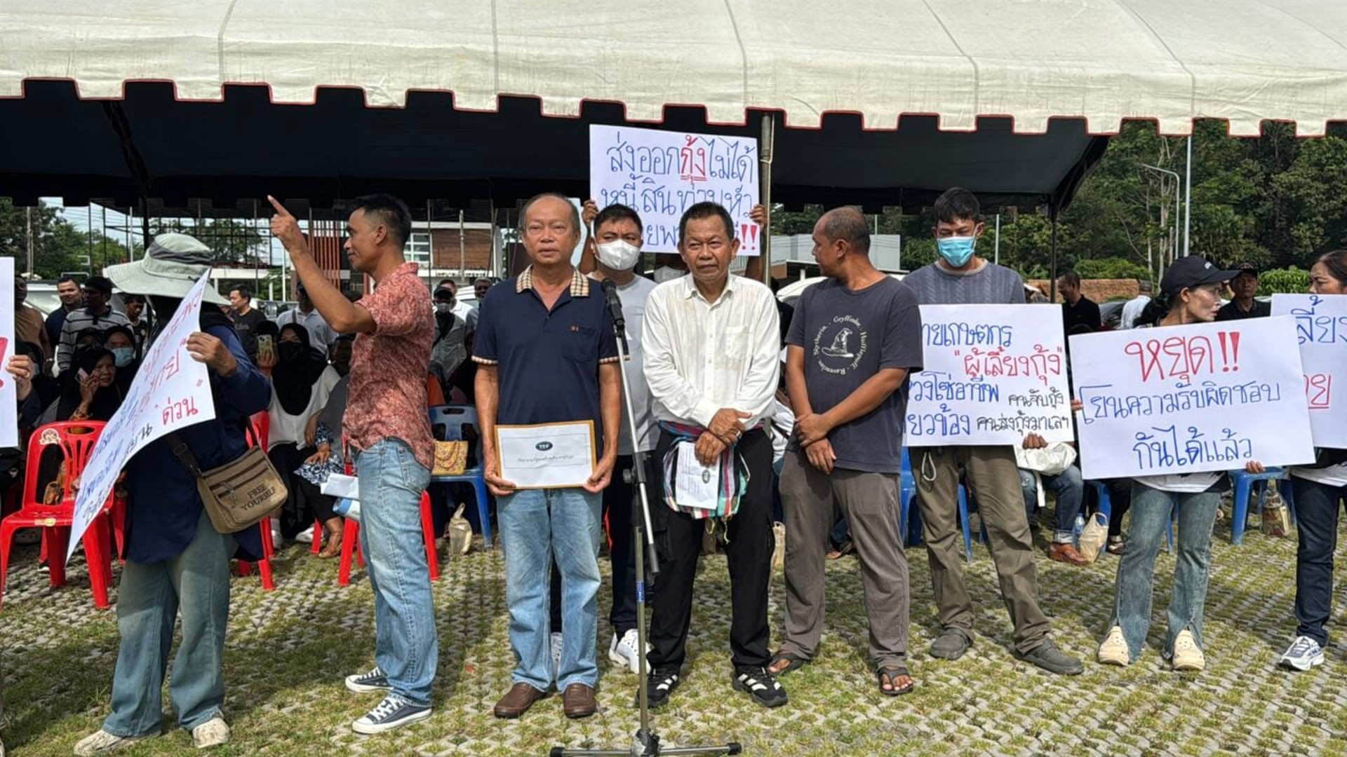 กลุ่มประชาชนถือป้ายและยื่นหนังสือหน้าการประชุม ครม.สัญจร