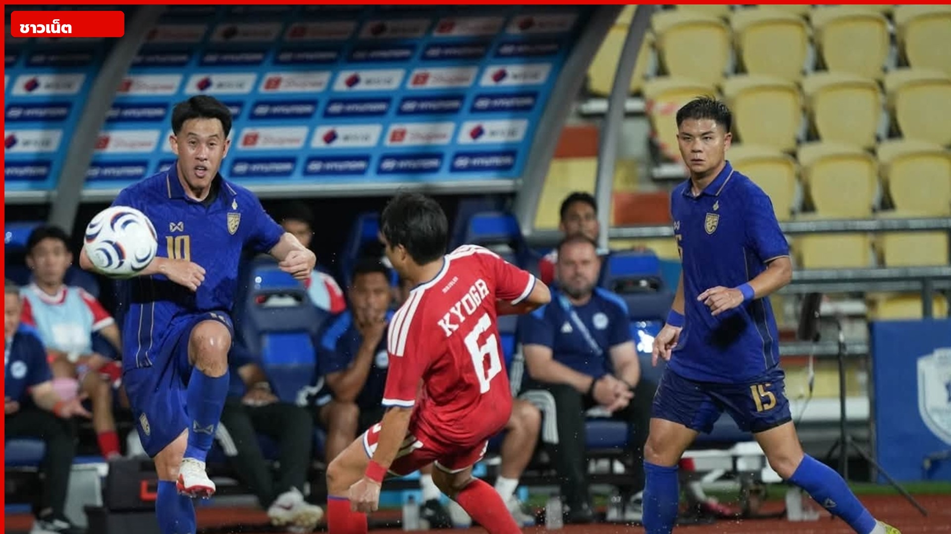 นักเตะไทยเสื้อน้ำเงินควบลูกบอลหน้านักเตะสิงคโปร์เสื้อแดง